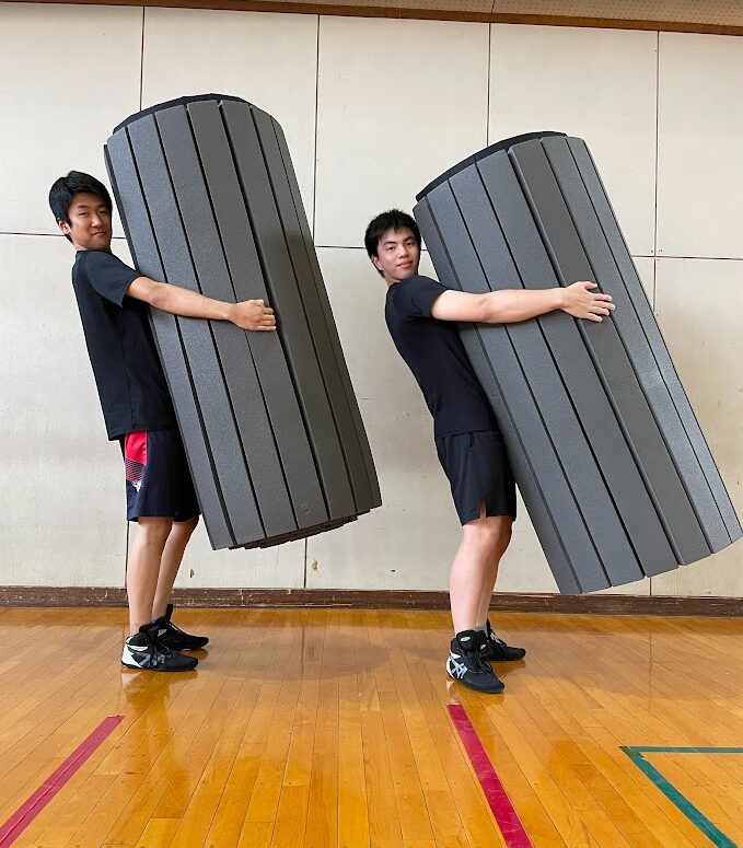 軽量で持ち運びやすいFiveFieldsマットを運搬する生徒
