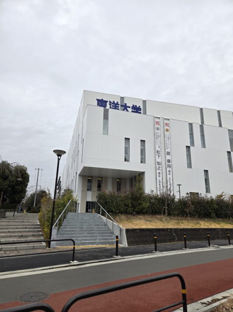 東洋大学で外部講師を務めるFiveFieldsの講義風景 校舎前の写真
